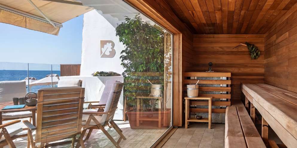 La Banya affacciata sul mare, con panche in legno