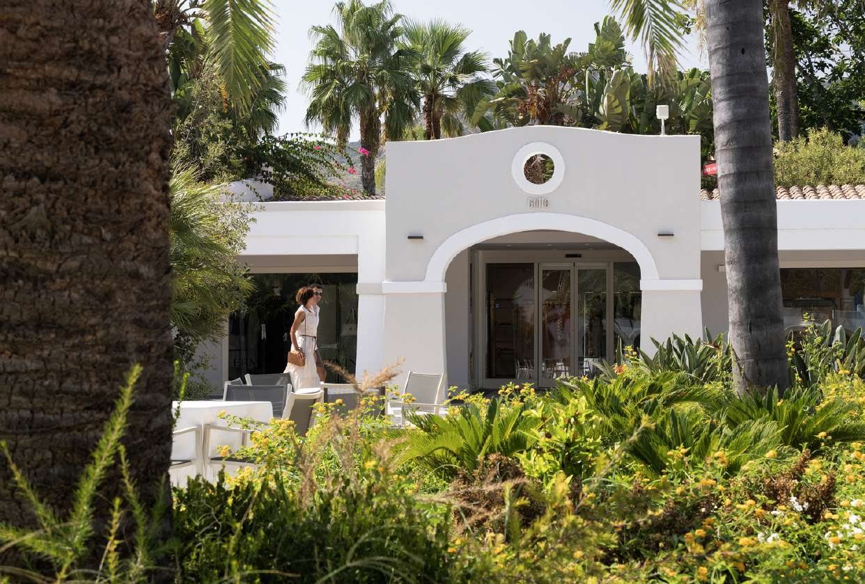 L’ingresso bianco delle boutique tra le palme