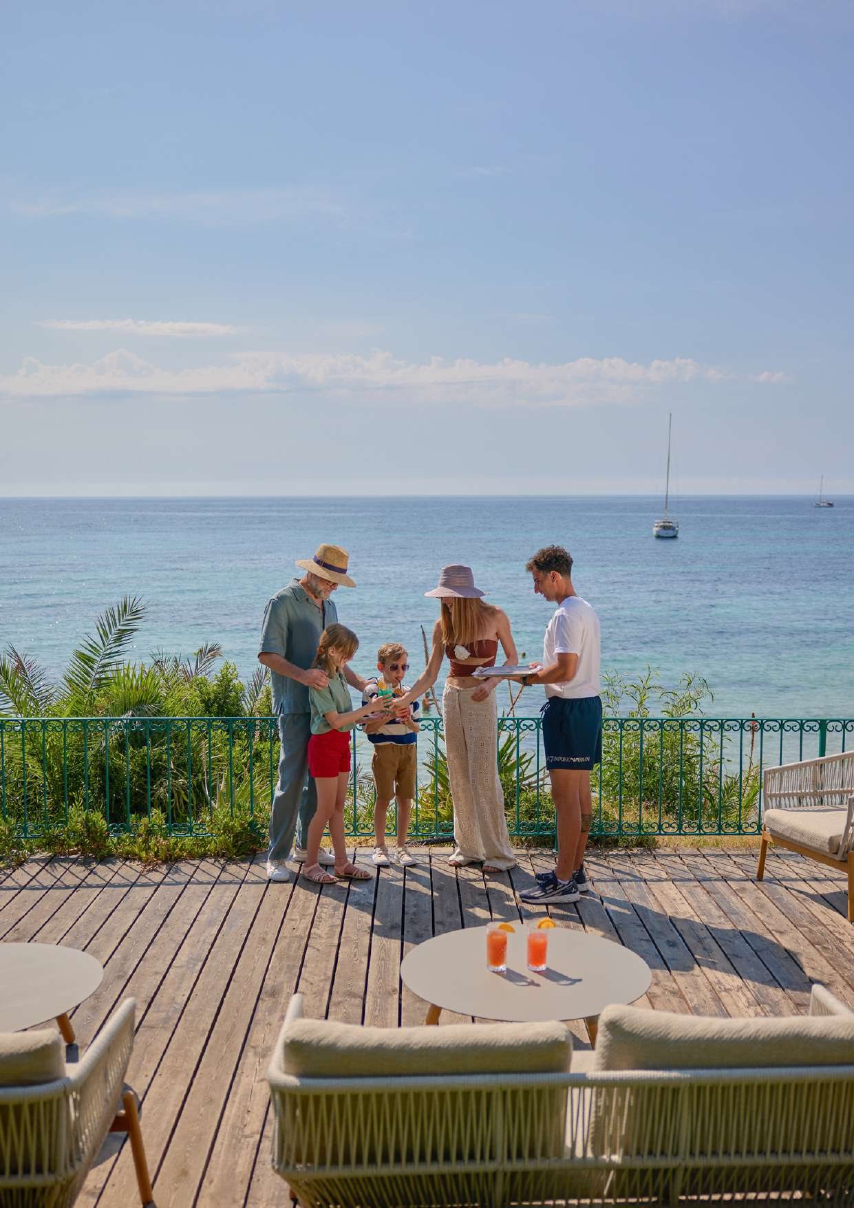 Una famiglia sulla terrazza in legno affacciata sul mare