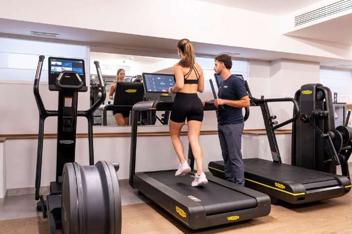 Un trainer segue un’ospite sul tapis roulant