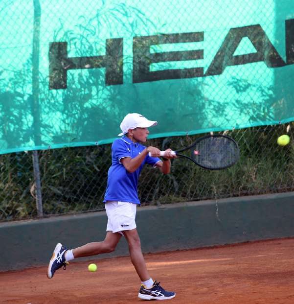 Un giovane tennista in corsa sulla terra rossa