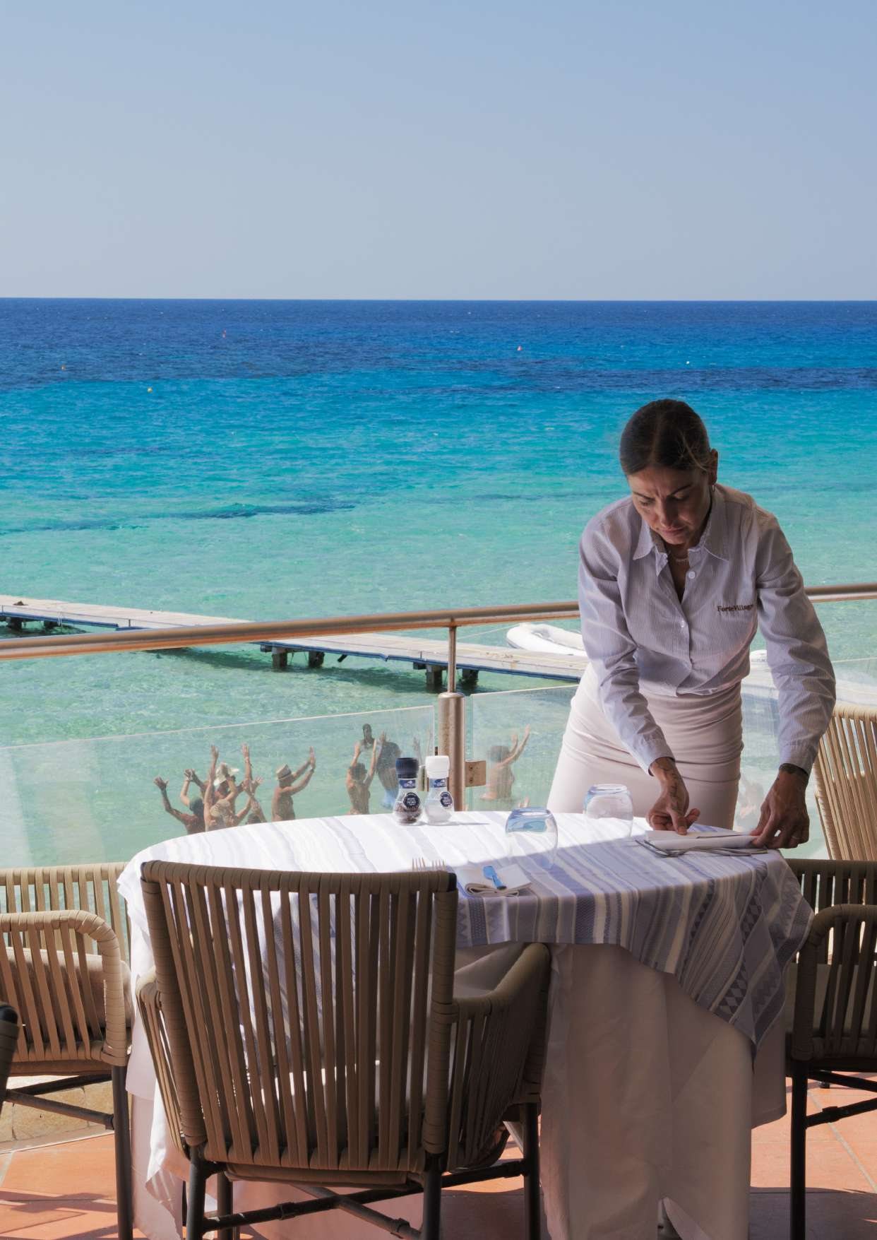 Un tavolo apparecchiato sulla terrazza affacciata sul mare